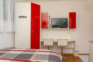 a bedroom with a bed and a desk and a tv at Apartments Caric in Hvar
