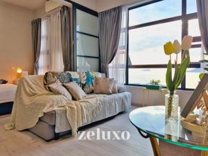 sala de estar con sofá y mesa de cristal en #1 Jesselton Quay City Pads Seaview by Zeluxo en Kota Kinabalu