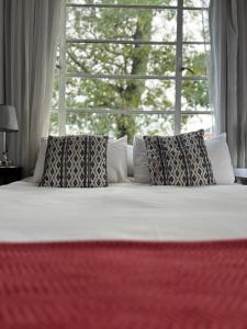 a bedroom with a bed with pillows and a window at Highlands Farm Cottage in Van Reenen