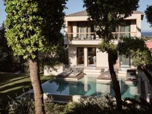 普拉諾斯的住宿－Sentiero Iconic Villa, a Serene Retreat, By ThinkVilla，享有带游泳池和树木的外部景致