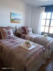 a bedroom with two beds with a tray with flowers on it at Apartamento Mirador del Pantano 1 in Vinuesa