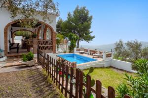 a backyard with a swimming pool and a wooden fence at Cortijo Fernando in Frigiliana