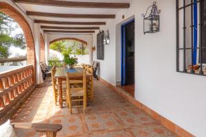 a room with a table and chairs on a balcony at Cortijo Fernando in Frigiliana