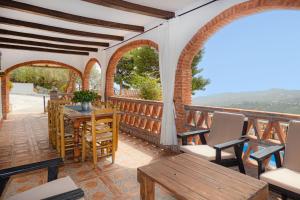 a room with a balcony with a table and chairs at Cortijo Fernando in Frigiliana