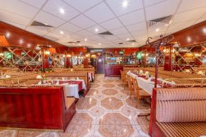 - un restaurant avec des tables et des chaises dans une salle dans l'établissement Szinbád Hotel, à Pécs