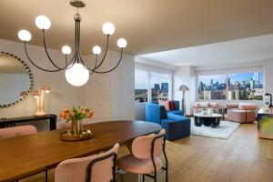 a living room with a dining room table with a blue couch at Downright Austin, A Renaissance Hotel - New Hotel in Austin