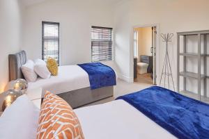 a bedroom with two beds and a bathroom at Sandside Beachfront Cottage Perfectly Saltburn in Saltburn-by-the-Sea