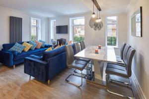 a living room with a table and a blue couch at Sandside Beachfront Cottage Perfectly Saltburn in Saltburn-by-the-Sea