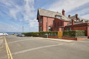 a red brick house on the side of a street at Sandside Beachfront Cottage Perfectly Saltburn in Saltburn-by-the-Sea