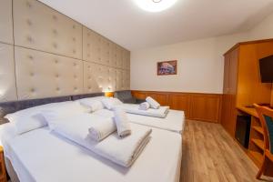 a bedroom with two beds with white pillows at Szinbád Hotel in Pécs
