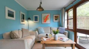 a living room with a couch and a table at Rebels Retreat - 2-Bed Chalet nr St Ives & Hayle in St Ives