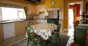 a kitchen with a table with a flowered table cloth at Jackie's Cottage in Claddaghduff