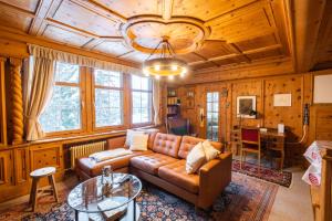 a living room with a couch and a table at Chalet Surselva in Arosa