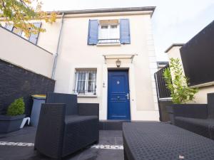 ein weißes Haus mit einer blauen Tür und Stühlen in der Unterkunft TEA&CHILL- Les Bluets - house with 2 terraces in Noisy-le-Sec