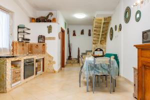 Una cocina y un comedor con mesa y sillas. en Villa Alice, en Villasimius 16 fotos más