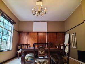 a dining room with a table and chairs and a chandelier at Fair Haven in Bloemfontein