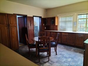 a kitchen with a table and chairs and cabinets at Fair Haven in Bloemfontein +13 photos