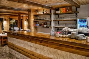a kitchen with a wooden counter with plates and dishes at Hotel Porto Tara in Žabljak