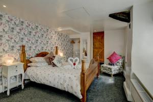 ein Schlafzimmer mit einem Bett und einem Stuhl in der Unterkunft Hartford Cottage West Anstey in East Anstey