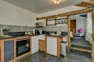 a kitchen with wooden cabinets and a counter top at Hartford Cottage West Anstey in East Anstey
