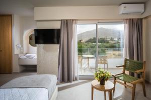 a hotel room with a bed and a balcony at South Coast in Makry Gialos
