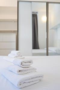 ein Haufen weißer Handtücher, die auf einer Theke vor einem Spiegel sitzen in der Unterkunft Dolce Rifugio, base Ideale per Esplorare la Città in Turin