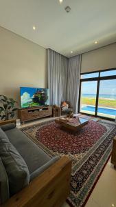 Water Front Villa BF108 في مسقط: غرفة معيشة مع أريكة وتلفزيون بشاشة مسطحة