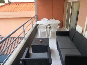 einen Balkon mit einem Tisch, Stühlen und einem Tisch in der Unterkunft 3 pièces 2 SDB centre de Cannes in Cannes