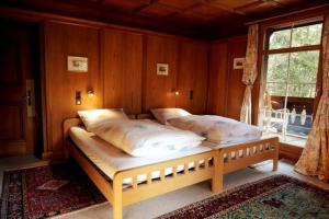 een slaapkamer met 2 bedden en een raam bij Chalet Surselva in Arosa