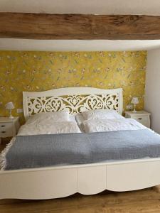um quarto com uma cama branca e papel de parede amarelo em Ferienhaus bei Juste em Schotten