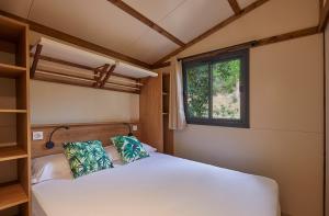 a bedroom with a white bed and a window at Camping Cala Pola in Tossa de Mar +118 photos