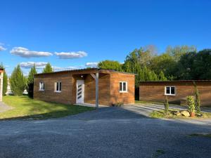a small wooden building with a parking lot at Les Chalets du Mancel : Chalet Lulu - Bouleries Jump - 24h du Mans in Parence