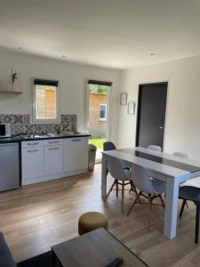 a kitchen and dining room with a table and chairs at Les Chalets du Mancel : Chalet Lulu - Bouleries Jump - 24h du Mans in Parence