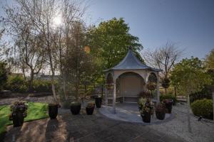 a gazebo in a garden with potted plants at Castletroy Park Hotel Suites in Limerick