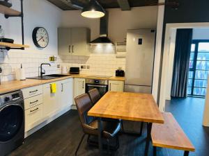 a kitchen with a wooden table and a sink at Homely 2-Bed Apartment with stunning Views Wembley in London