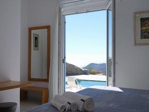 a bedroom with a bed and a view of a pool at Chrysanthemo villas in Ano Mera