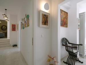 a hallway with a chair and paintings on the wall at Chrysanthemo villas in Ano Mera