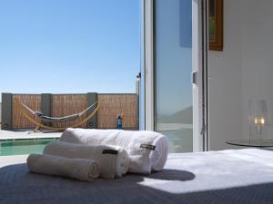 ein Schlafzimmer mit einem Bett mit Handtüchern darauf in der Unterkunft Chrysanthemo villas in Ano Mera