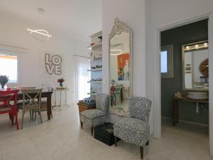 - un salon avec une table, des chaises et un miroir dans l'établissement Chrysanthemo villas, à Ano Mera
