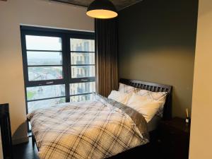 sypialnia z łóżkiem i dużym oknem w obiekcie Homely 2-Bed Apartment with stunning Views Wembley w Londynie