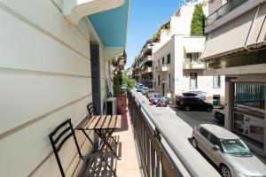 einen Balkon mit einem Tisch und einem Auto auf einer Straße in der Unterkunft Beautiful Neo-Classic apartment in Exarchia (1Bed) in Athen