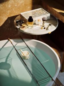 a glass table with a bath tub and a sink at The Lana - Dorchester Collection in Dubai