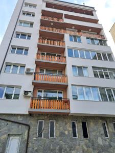 an apartment building with balconies on a stone wall at Apartment Beti in Devin
