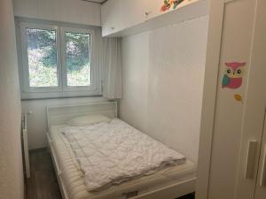 - un petit lit dans une chambre avec 2 fenêtres dans l'établissement Remointze COSY & CENTER apartments by Alpvision Résidences, à Veysonnaz