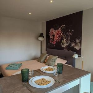 a room with a bed and a table with plates of food at Appartement proche du centre in Mulhouse