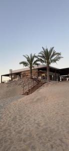 een gebouw op het strand met palmbomen voor de deur bij Water Front Villa BF108 in Muscat