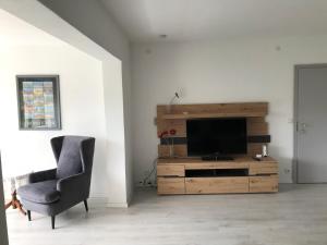 a living room with a television and a chair at Ferienwohnung Felgenwald in Michelstadt