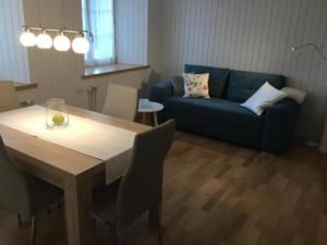 a living room with a table and a blue couch at Ferienwohnung Hirschli in Grub