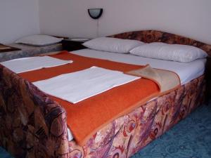 Bett in einem Zimmer mit 2 weißen Laken in der Unterkunft Appartement in Novi Vinodolski mit Terrasse, Garten und Grill in Novi Vinodolski