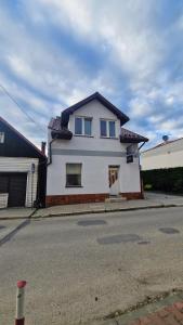 a white house sitting on the side of a street at Apartament w centrum Piwnicznej in Piwniczna-Zdrój